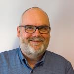 Portrettfoto av mann med lite hår, briller, skjegg