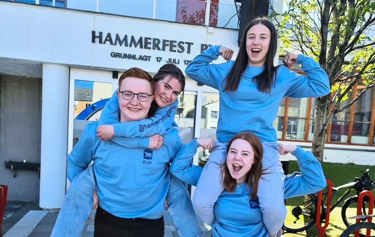 En gruppe ungdommer jubler foran Hammerfest rådhus - Klikk for stort bilde
