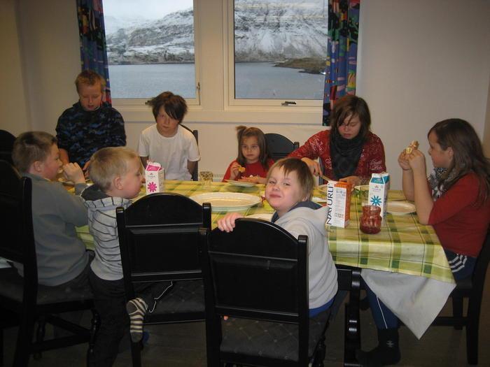Mange barn samlet rundt et matbord - Klikk for stort bilde