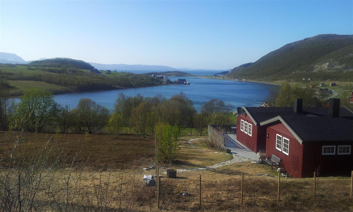 Rødt hus foran fjord - Klikk for stort bilde